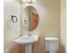 Cozy bathroom featuring a pedestal sink, toilet, oval mirror, and bronze fixtures at 5274 Brooks Bnd, Greenwood, IN 46143