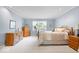 Spacious bedroom with light blue walls, plush carpet, wooden furniture, and bright natural light at 54 Horseshoe Ln, Carmel, IN 46033