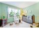 Bedroom with green walls, white armchair, dark wood crib, and natural light at 54 Horseshoe Ln, Carmel, IN 46033