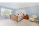 A well-lit bedroom featuring light blue walls and carpet, with a rocking chair and wooden bed frame at 54 Horseshoe Ln, Carmel, IN 46033