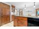 Kitchen with wooden cabinets and black appliances, adjacent to a hallway and dining area at 54 Horseshoe Ln, Carmel, IN 46033