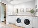 Functional laundry room with modern washer and dryer, cabinetry, and tile flooring at 54 Horseshoe Ln, Carmel, IN 46033