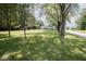 Two-story home with a lush green lawn, mature trees, and a long gravel driveway at 5707 In-234, McCordsville, IN 46055
