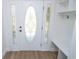 Elegant front door with decorative glass sidelights and transom, complemented by a built-in entryway bench and storage at 5707 In-234, McCordsville, IN 46055