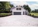 Detached two-car garage with dark trim, gravel driveway, and exterior stairs at 5707 In-234, McCordsville, IN 46055