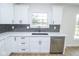 Modern kitchen with black stainless steel appliances, a herringbone backsplash, and white cabinets with sleek hardware at 5707 In-234, McCordsville, IN 46055