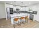 Modern kitchen featuring white cabinets, stainless steel appliances, a center island with bar stools, and elegant pendant lighting at 5707 In-234, McCordsville, IN 46055