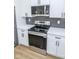 Modern kitchen showcasing stainless steel range, microwave and white cabinets complemented by black hardware and herringbone backsplash at 5707 In-234, McCordsville, IN 46055