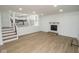 Finished living room featuring hardwood floors, a staircase, fireplace, and open access to the kitchen at 5707 In-234, McCordsville, IN 46055