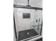 Modern walk-in shower with glass door and black accents and marble-look tile and black hexagonal tiled floor at 5707 In-234, McCordsville, IN 46055