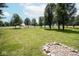 Grassy yard with mature trees, plus a rock firepit area for outdoor gatherings at 5707 In-234, McCordsville, IN 46055