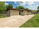 Tan brick single-story home with a concrete patio and green grassy yard at 5927 Meadowood Dr, Speedway, IN 46224