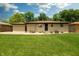 Home's backyard with grassy area, stone facade, and outdoor seating space at 5927 Meadowood Dr, Speedway, IN 46224