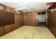 Finished basement with a carpeted floor, wood paneled walls and built in storage shelves at 5927 Meadowood Dr, Speedway, IN 46224