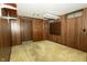 Finished basement with a carpeted floor, wood paneled walls and built in storage shelves at 5927 Meadowood Dr, Speedway, IN 46224