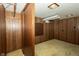 Finished basement with a carpeted floor, wood paneled walls and built in storage shelves at 5927 Meadowood Dr, Speedway, IN 46224