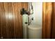 Basement utility area with a water filter, water softener, and wood paneling at 5927 Meadowood Dr, Speedway, IN 46224