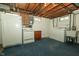 Unfinished basement area with laundry hookups, refrigerator, and utility sink at 5927 Meadowood Dr, Speedway, IN 46224