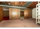 Partially finished basement with wood paneled walls, carpet, and doorway entries to other rooms at 5927 Meadowood Dr, Speedway, IN 46224