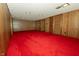 Large basement with wood paneled walls, vintage doors, and red carpeting at 5927 Meadowood Dr, Speedway, IN 46224