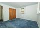 Bedroom featuring wood closet doors, and blue carpet at 5927 Meadowood Dr, Speedway, IN 46224