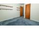 Bedroom featuring neutral paint, wood door and blue carpet at 5927 Meadowood Dr, Speedway, IN 46224