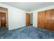 Bedroom with blue carpeting, wood closets, and neutral walls at 5927 Meadowood Dr, Speedway, IN 46224