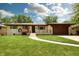 Charming ranch home with a manicured lawn, quaint walkway, and attached garage at 5927 Meadowood Dr, Speedway, IN 46224