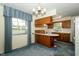 Bright kitchen featuring updated appliances, classic wood cabinets, and ample lighting at 5927 Meadowood Dr, Speedway, IN 46224