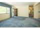 Light filled living room with blue carpet adjacent to entryway and hallway at 5927 Meadowood Dr, Speedway, IN 46224