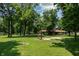 Lush park area with a swing set, and a distant picnic shelter at 5927 Meadowood Dr, Speedway, IN 46224