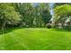 Lush green backyard featuring a spacious lawn and mature trees, perfect for outdoor enjoyment at 6118 Deerwood Dr, Greenwood, IN 46143