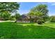 Spacious backyard offering a well-kept lawn and a view of the home's back exterior and deck at 6118 Deerwood Dr, Greenwood, IN 46143