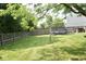 Large backyard with well maintained lawn, wood privacy fence, mature trees and trampoline at 6563 Enclave Blvd, Greenwood, IN 46143