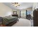 A spacious bedroom with lots of natural light, ceiling fan, and a TV with an entertainment console at 6563 Enclave Blvd, Greenwood, IN 46143