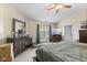 Cozy bedroom with a ceiling fan, dresser, window view, and television set for ultimate relaxation at 6563 Enclave Blvd, Greenwood, IN 46143