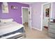 Purple bedroom with a queen size bed, a doorway to a closet, and a doorway to another room at 6563 Enclave Blvd, Greenwood, IN 46143