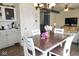 Light-filled dining area with wood table, white chairs and a view to the living room with a fireplace at 6563 Enclave Blvd, Greenwood, IN 46143