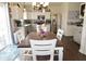 Well-lit dining area with a dark wood table, white chairs, and a view of the modern kitchen and stainless appliances at 6563 Enclave Blvd, Greenwood, IN 46143