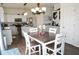 Open-concept dining and kitchen area with wood floors, a view of stainless steel appliances, and white cabinetry at 6563 Enclave Blvd, Greenwood, IN 46143
