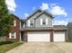 Charming two-story home featuring a two-car garage, brick accents, and gray siding at 6563 Enclave Blvd, Greenwood, IN 46143