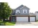 Charming two-story home featuring a brick and vinyl exterior with a two-car garage and well-maintained lawn at 6563 Enclave Blvd, Greenwood, IN 46143