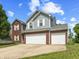 Charming two-story home featuring a two-car garage, brick accents, and gray siding at 6563 Enclave Blvd, Greenwood, IN 46143