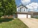 Attractive home with a well-manicured lawn, brick accents, and an attached two-car garage at 6563 Enclave Blvd, Greenwood, IN 46143
