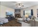 Cozy living room featuring a brick fireplace, ceiling fan, and comfortable seating area with lots of natural light at 6563 Enclave Blvd, Greenwood, IN 46143