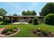 Spacious backyard featuring a patio, garden beds with colorful flowers, and lush green grass for outdoor enjoyment at 7150 Combs Rd, Indianapolis, IN 46237