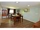 Bright dining room with a table set for six, wooden floors, and a view from the window at 7150 Combs Rd, Indianapolis, IN 46237