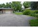 Wide paved driveway leading to a one-car garage, with lush greenery surrounding the property at 7150 Combs Rd, Indianapolis, IN 46237