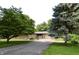 Charming single-story home with a brick exterior, mature trees, and a paved driveway at 7150 Combs Rd, Indianapolis, IN 46237