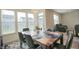 Dining room area features a wood table, seating for six, large bright window, and adjacent living space at 7284 Bayview Run, McCordsville, IN 46055